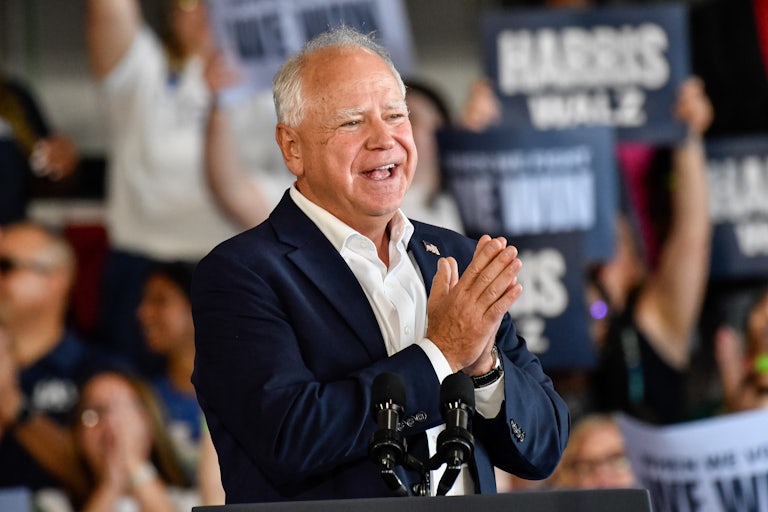 Tim Walz holds his hands together during a rally with Kamala Harris